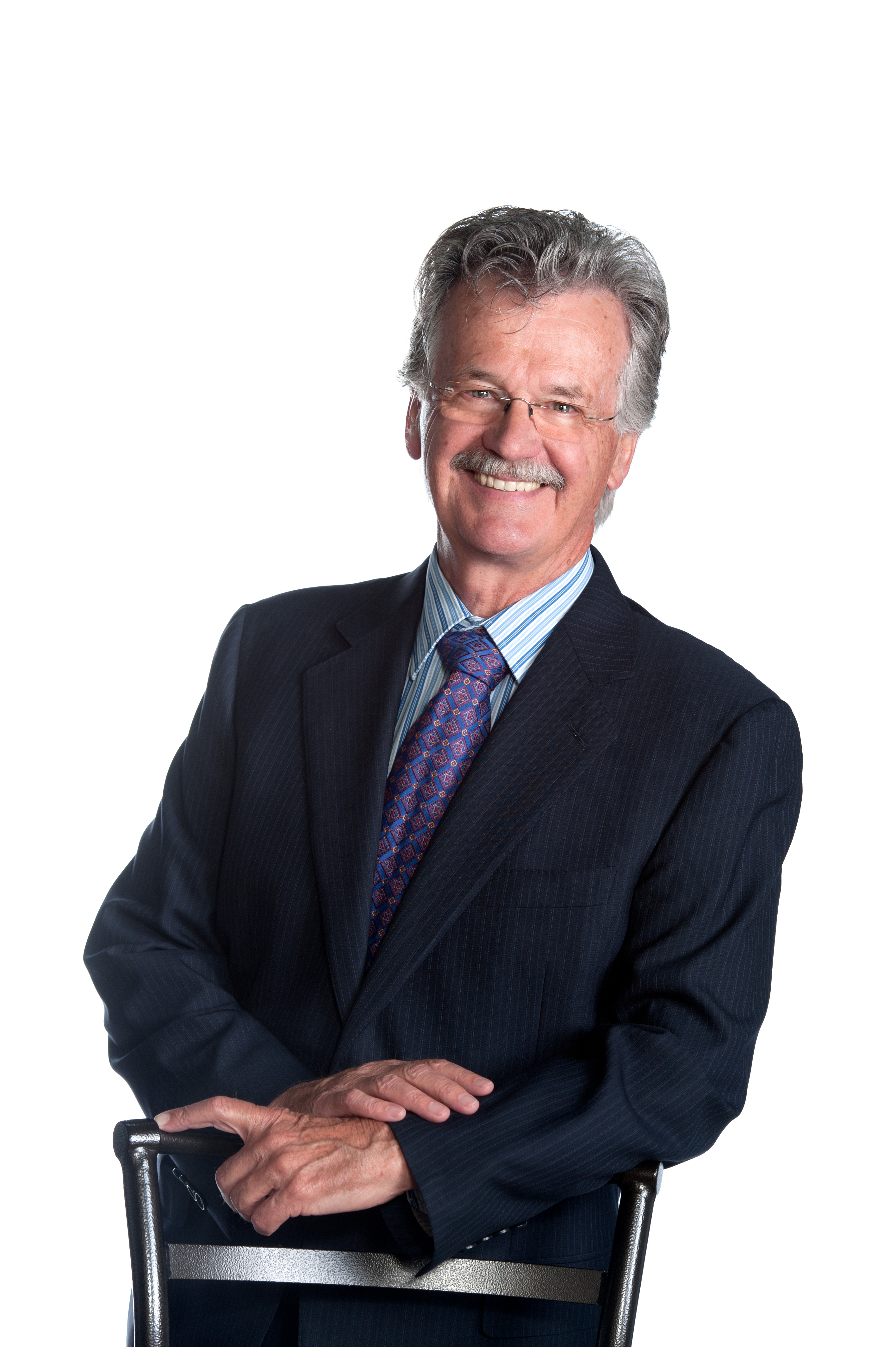 Garth Roberts, in suit & tie, leaning on chair